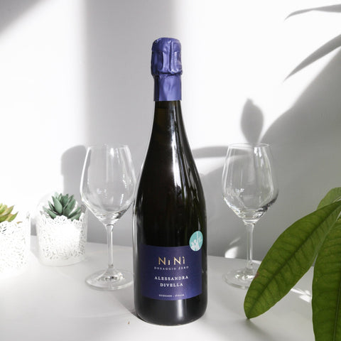 Bouteille de vin mousseux biologique de la Lombardie en Italie par Alessandra Divella : Nini. Un vin nature à se procurer en importation privée au Québec. Parfait pour vos accords mets-vins grâce à la sélection de Le vin dans les voiles.